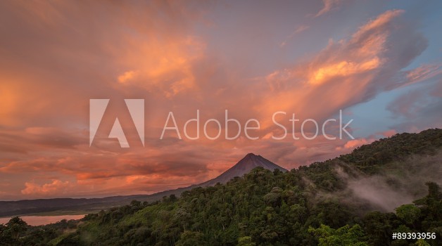 Picture of Sunset on Lake Arenal and Arenal Volcano in Costa Rica brings Shades of red and orange as clouds rise from the jungle floor